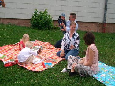 Eltern genießen gemeinsam mit Ihren Kindern den Sommergarten